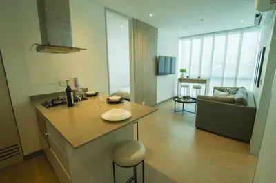 a kitchen and living room with a table and a couch at Suite de lujo Distrito 90 in Barranquilla