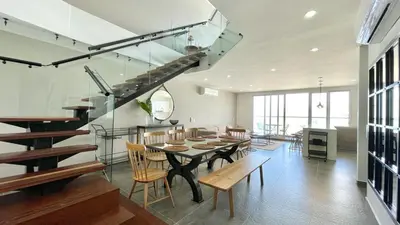 a dining room with a table and chairs and a staircase at Penthouse en zona norte cartagena luxury con 3 habitaciones y excelente wifi in Cartagena de Indias