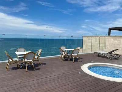 a deck with tables and chairs next to a swimming pool at Penthouse en zona norte cartagena luxury con 3 habitaciones y excelente wifi in Cartagena de Indias