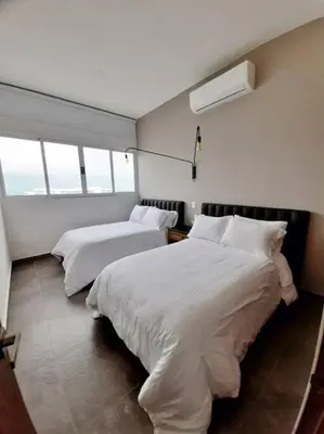 a bedroom with two beds with white sheets and windows at Penthouse en zona norte cartagena luxury con 3 habitaciones y excelente wifi in Cartagena de Indias