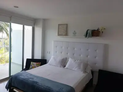 a bedroom with a bed with a large white headboard at Apartamento Morros vitri 214 zona norte in Cartagena de Indias