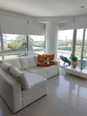 a white couch in a living room with windows at Apartamento Morros vitri 214 zona norte in Cartagena de Indias