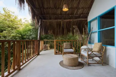 a porch with two chairs and a table at Fenix Beach Cartagena in Tierra Bomba