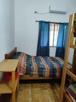 a bedroom with a bed and a desk and a window at El ensueño in San Bernardo del Viento