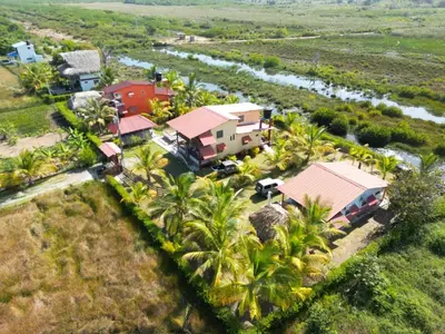 an aerial view of a house with palm trees and a river at El ensueño in San Bernardo del Viento