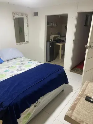a bedroom with a bed with a blue blanket on it at Habitación independiente cerca al mar. in Puerto Salgar
