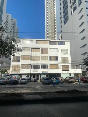 a large white building with cars parked in a parking lot at Ubicación increíble! cerca del centro y del mar in Cartagena de Indias