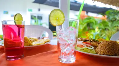 a table with a plate of food and a drink at Casa Hotel Las Antillas in Tolú