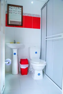 a bathroom with a white toilet and a sink at Casa Hotel Las Antillas in Tolú