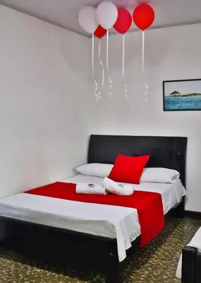 a bedroom with a bed with red and white balloons at Casa Hotel Las Antillas in Tolú