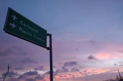 a green street sign in front of a cloudy sky at Cabaña El Faro in Tubará