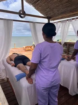 a woman standing in front of a man on beds at Múcura Club Hotel in Isla Mucura