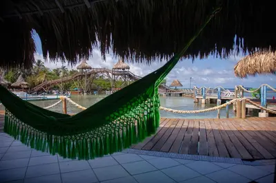 a hammock in a straw umbrella on a beach at Múcura Club Hotel in Isla Mucura