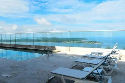 a group of lounge chairs sitting next to a swimming pool at Apartamento El Laguito Cartagena in Cartagena de Indias