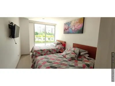 a bedroom with two beds and a tv and a window at Santa Marta Apartamento en Bello Horizonte in Santa Marta
