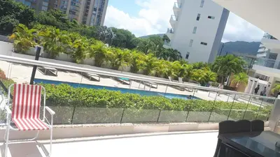 a chair sitting on a balcony with a pool at Santa Marta Apartamento en Bello Horizonte in Santa Marta