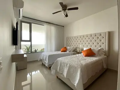 a bedroom with two beds and a ceiling fan at Paraíso frente al Mar Caribe en Cartagena. in Cartagena de Indias