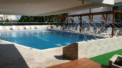a large swimming pool with white chairs at Apartamento en Cartagena Colombia in Cartagena de Indias
