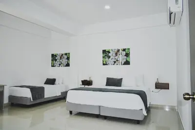 two beds in a room with white walls at Hotel El Marqués De Manga in Cartagena de Indias