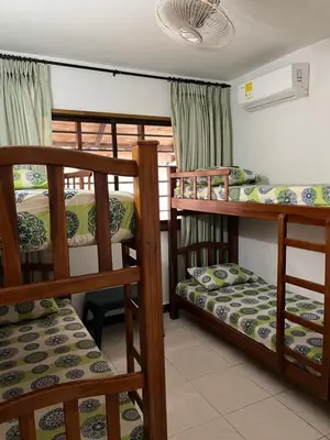 a room with three bunk beds and a window at Cabaña en coveñas in Coveñas