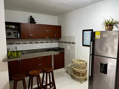 a kitchen with a stainless steel refrigerator and wooden cabinets at Cabaña en coveñas in Coveñas