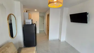 a living room with a black refrigerator and a television at Oceanfront loft in high level neighborhood in Cartagena de Indias