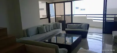 a living room with a couch and a chair and a glass table at Modern Duplex Balcony Sea View Mr8 in Cartagena de Indias