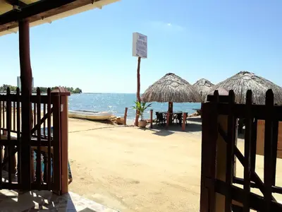 a fence on a beach with umbrellas and the ocean at Hotel Costa Mar Coveñas in Coveñas