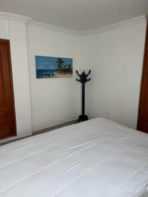 a bedroom with a bed with a cross on the wall at Bonito apartamento en Cartagena con garaje gratuito in Cartagena de Indias