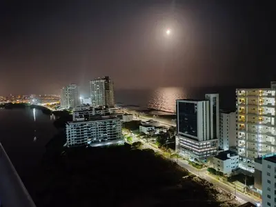 a view of a city at night with the moon at P23 Brand New high floor, few blocks to walled city steps to beach in Cartagena de Indias