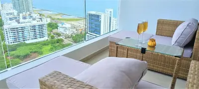 a balcony with a table and chairs and a view of the ocean at P23 Brand New high floor, few blocks to walled city steps to beach in Cartagena de Indias