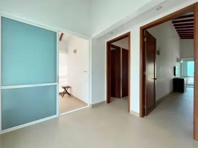 a hallway with doors and a room with a table at Casa Arcoíris: Espectacular casa en Cartagena con Acceso directo a la Playa in Cartagena de Indias