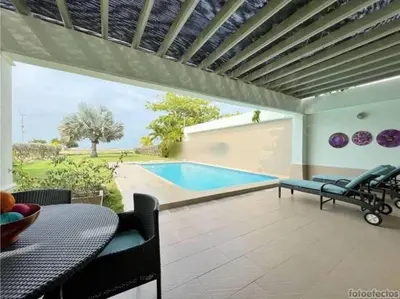 a patio with a pool and a table and chairs at Casa Arcoíris: Espectacular casa en Cartagena con Acceso directo a la Playa in Cartagena de Indias