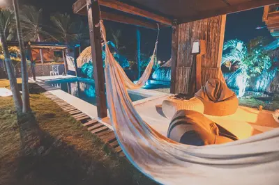 a hammock in a resort with a person sleeping in it at KokohauBungalows in Santa Veronica