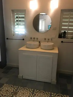 a bathroom with two sinks and a mirror at KokohauBungalows in Santa Veronica