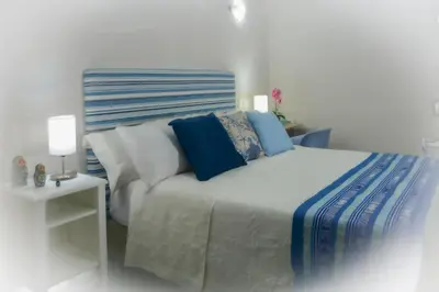 a bedroom with a bed with blue and white pillows at Casa Lorenza Hotel in Cartagena de Indias