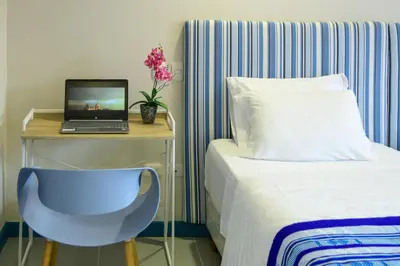 a bedroom with a bed and a desk with a laptop at Casa Lorenza Hotel in Cartagena de Indias