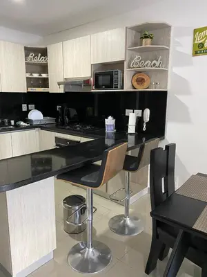 a kitchen with a black counter and two chairs at Edificio NUEVO DE LUJO CARTAGENA BOCAGRANDE in Cartagena de Indias