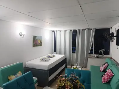 a room with a bed and a couch and chairs at Excelente vista al mar in Cartagena de Indias