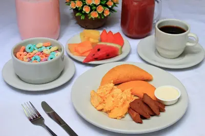 a table with plates of food and cups of coffee at Hotel Abi Inn By GEH Suites in Cartagena de Indias
