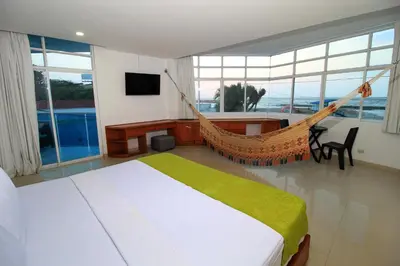 a hammock in a bedroom with a view of the ocean at Hotel Abi Inn By GEH Suites in Cartagena de Indias