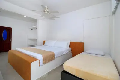 a bedroom with two beds and a ceiling fan at Hotel Abi Inn By GEH Suites in Cartagena de Indias