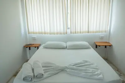 a white bed with towels and a bow on it at La Playita Isla Fuerte in Isla Fuerte
