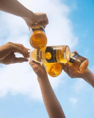 a group of people holding bottles of beer at La Playita Isla Fuerte in Isla Fuerte