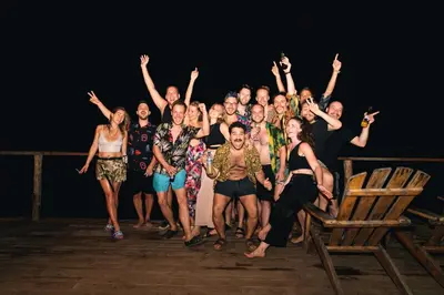 a group of people standing on a stage with their hands in the air at La Playita Isla Fuerte in Isla Fuerte