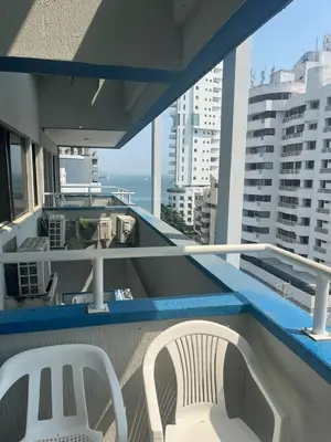two white chairs on a balcony with a view of the ocean at Lindo Apartamento cerca al mar in Cartagena de Indias