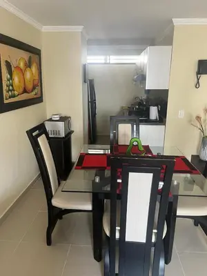 a dining room with a table and chairs and a kitchen at Lindo Apartamento cerca al mar in Cartagena de Indias