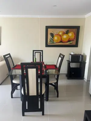 a dining room table with chairs and a picture of fruit at Lindo Apartamento cerca al mar in Cartagena de Indias