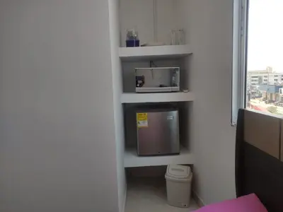 a room with a shelf with a microwave and a trash can at DULCE HOGAR in Cartagena de Indias