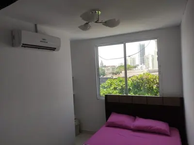 a bedroom with a purple bed and a window at DULCE HOGAR in Cartagena de Indias
